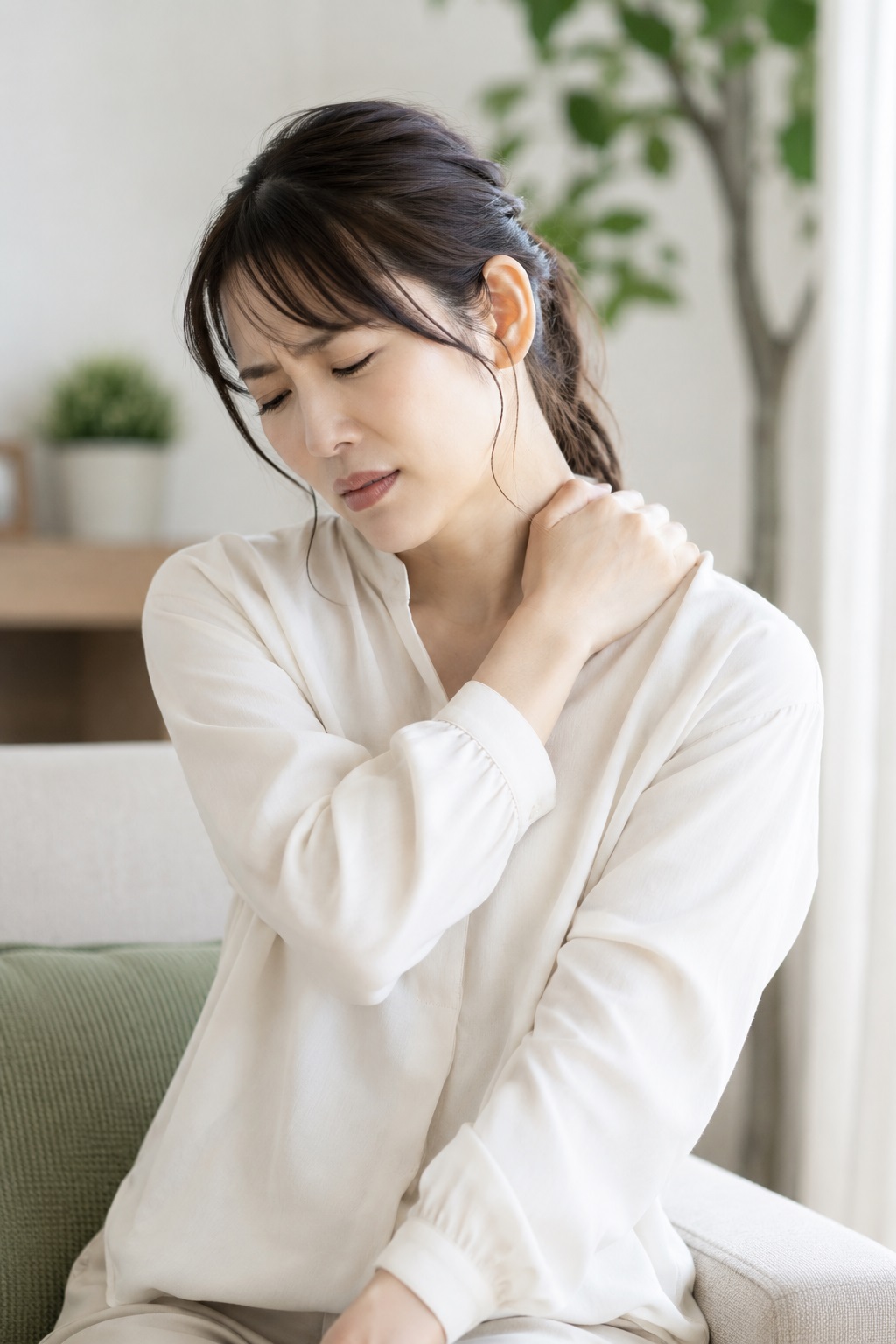 肩こりを放置すると慢性化につながることがあります 肩こりや首こりによる痛みで肩を押さえる女性